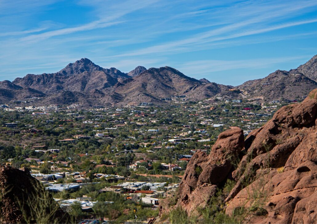 Panoramic view of Phoenix, Arizona, showcasing residential areas and mountains, emphasizing the city's appeal for senior living and outdoor activities.