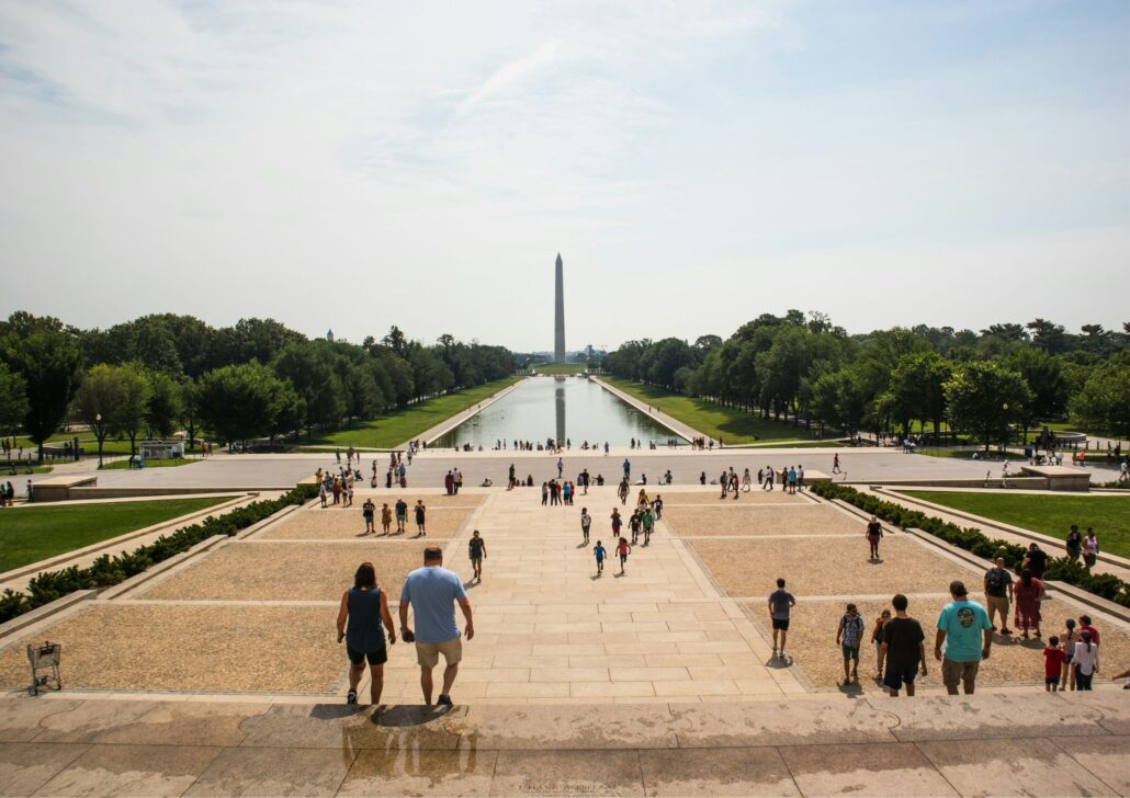 View of the Lincoln Memorial Reflecting Pool in Washington D.C., with visitors walking along the steps and enjoying the greenery, highlighting the city's cultural and historical significance for seniors.