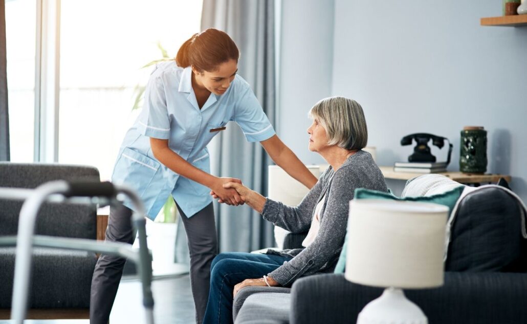 Caregiver assisting elderly woman in a cozy living room, emphasizing support and companionship in senior care.