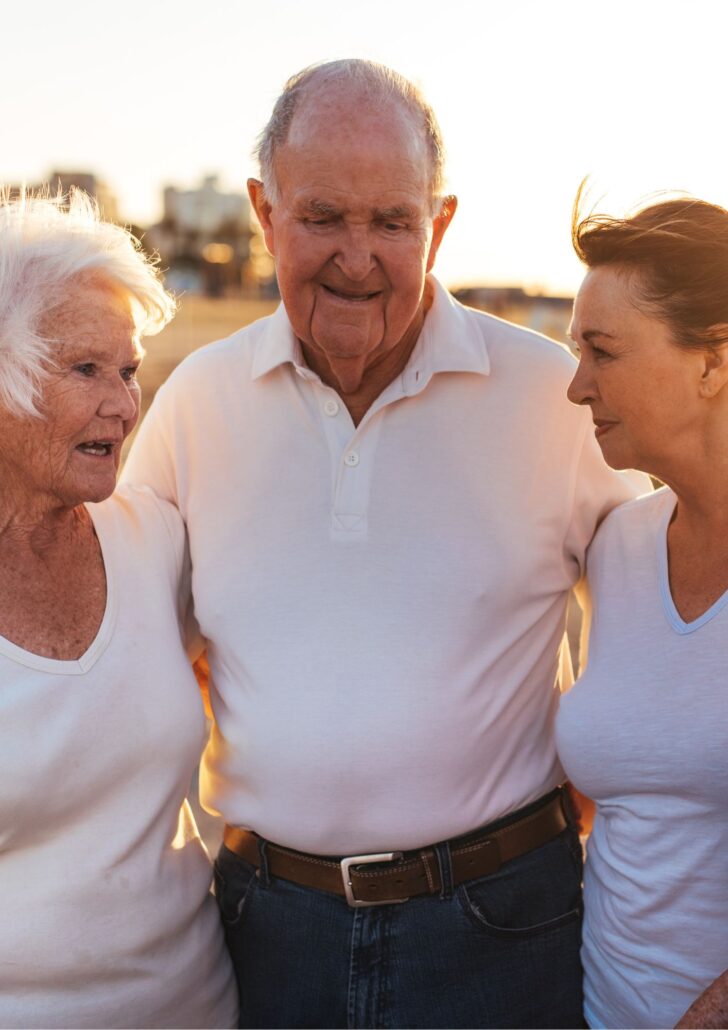 Seniors enjoying a warm moment together outdoors, emphasizing connection and support in the aging journey.